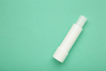 Lip balm on mint background. Top view