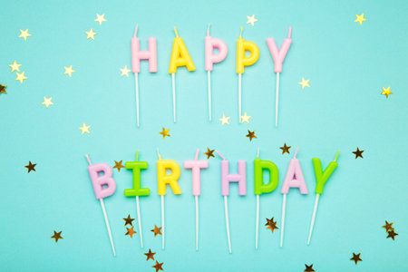 Happy birthday candles with gold stars on blue background. Top viewの写真素材