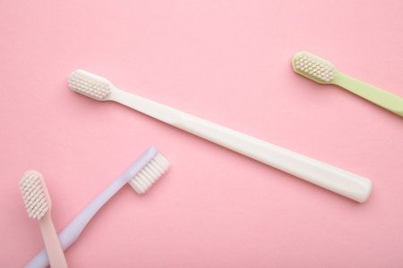 Patel toothbrushes on pink background. Dental health and hygiene concept. Top viewの写真素材