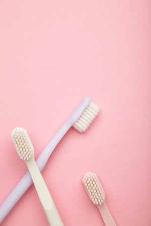 Toothbrushes on pink background. Dental health and hygiene concept. Top view