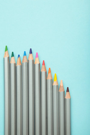 Many colorful pencils on blue background. Top view