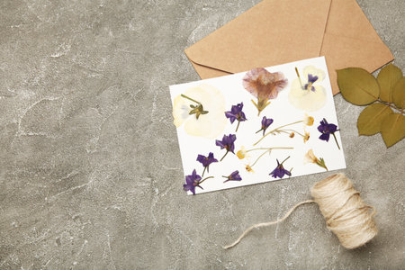Pressed and dried flowers with twine on gray concrete background. Space for textの写真素材