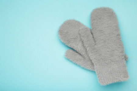 Winter mittens on blue background, warm mittens. Space for textの写真素材