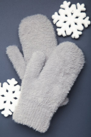 Winter gray mittens with snowflakes on dark blue background, warm mittens. Top viewの写真素材