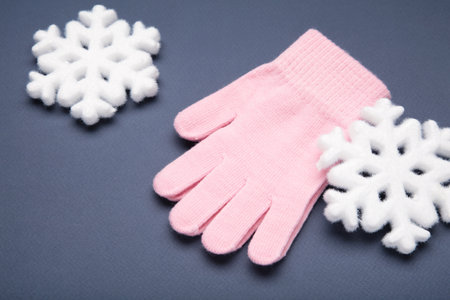 Warm woolen knitted gloves on blue background. Space for textの写真素材