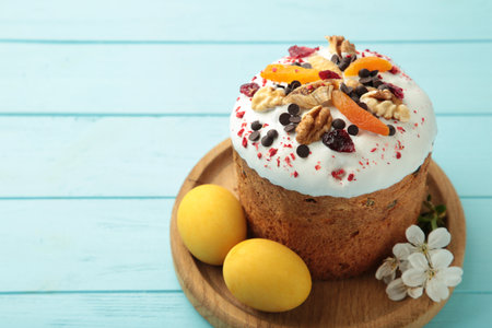 Traditional easter cakes with colorful sprinkles, with eggs and spring flowers on blue wooden backgroundの写真素材