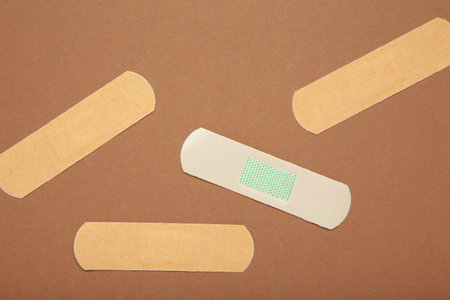 Medical sticking plasters on brown background. First aid item. Top viewの写真素材