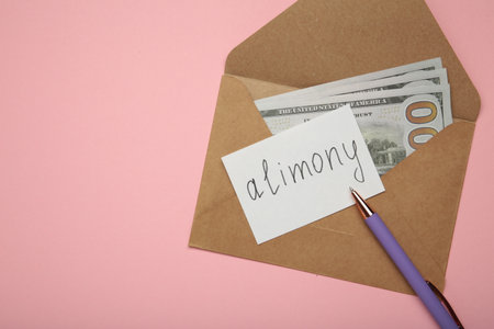 Envelope with word Alimony and money on pink background. Top viewの写真素材