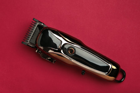 Hair clipper on red background. Modern hair clipper. Top viewの写真素材