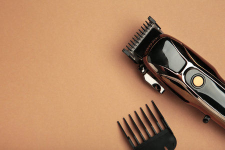 Hair clipper on brown background. Modern hair clipper. Top view