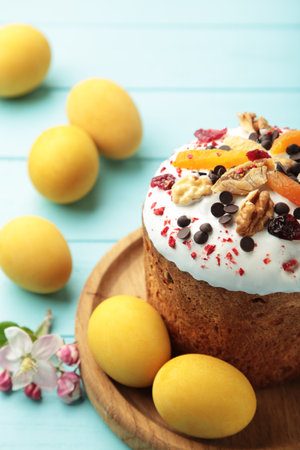 Traditional easter cakes with colorful sprinkles, with eggs on blue wooden background. Top view