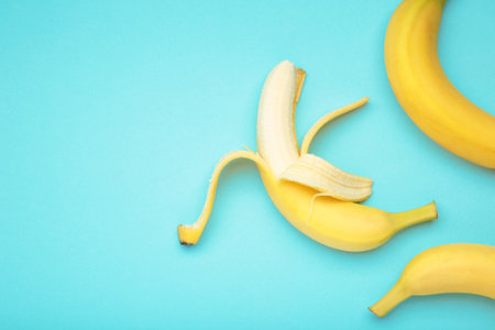 Open ripe banana on blue background. Space for text. Top viewの写真素材