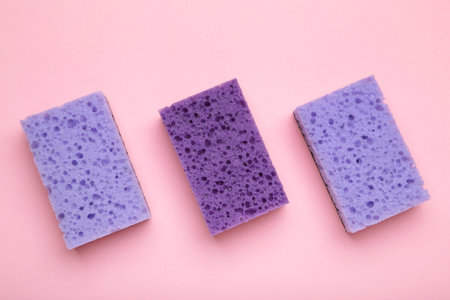 Violet dishwashing sponges on pink background. Household cleaning sponge. Vertical photoの写真素材