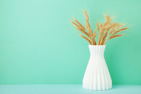 Spikelets of wheat in a vase on background. Space for textの写真素材
