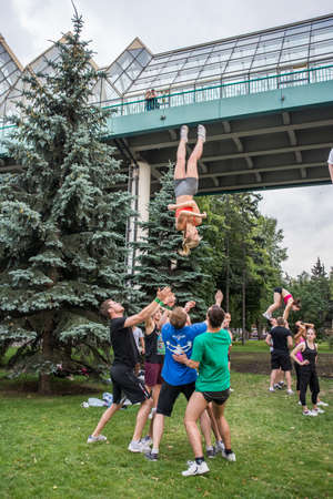 Boys and girls do gymnastics in a summer park on the banks of a riverのeditorial素材