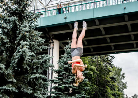 Boys and girls do gymnastics in a summer park on the banks of a riverのeditorial素材
