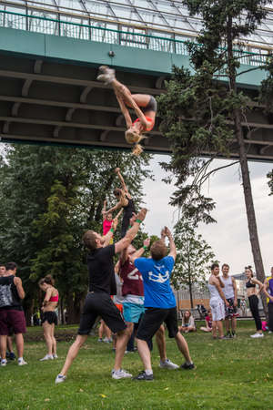 Boys and girls do gymnastics in a summer park on the banks of a riverのeditorial素材