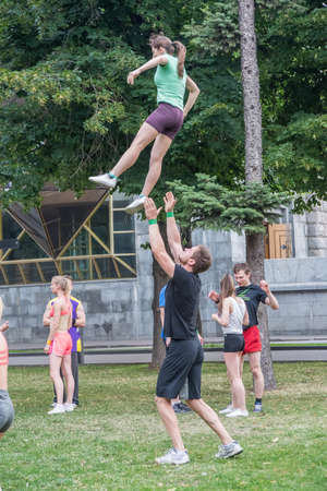Boys and girls do gymnastics in a summer park on the banks of a riverのeditorial素材