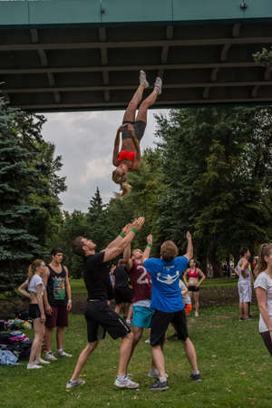 Boys and girls do gymnastics in a summer park on the banks of a riverのeditorial素材