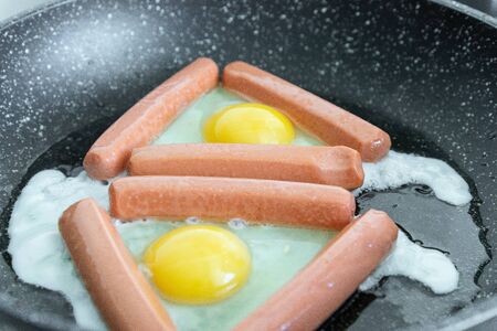Fried eggs and fried sausages for breakfast or dinnerの写真素材