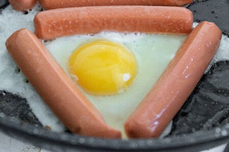 Fried eggs and fried sausages for breakfast or dinnerの写真素材