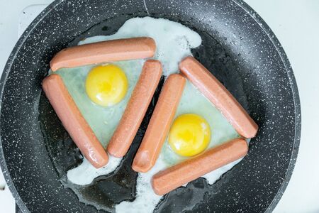 Fried eggs and fried sausages for breakfast or dinnerの写真素材