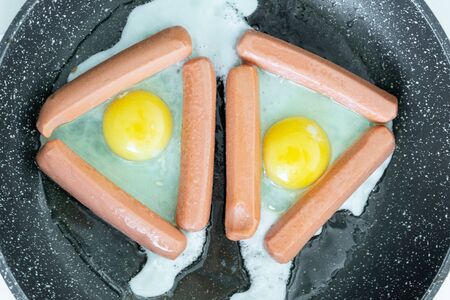 Fried eggs and fried sausages for breakfast or dinnerの写真素材