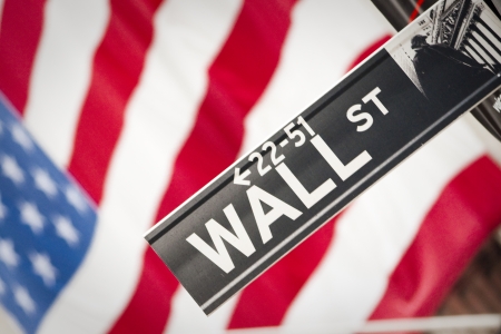 Wall Street Sign with US Flag Behindの写真素材