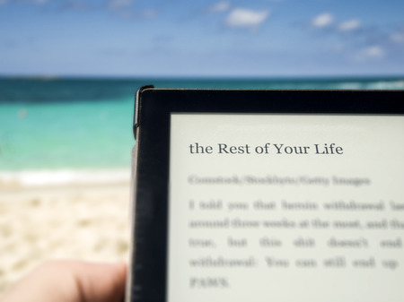 Reading on the beach with the title "the rest of your life"の写真素材