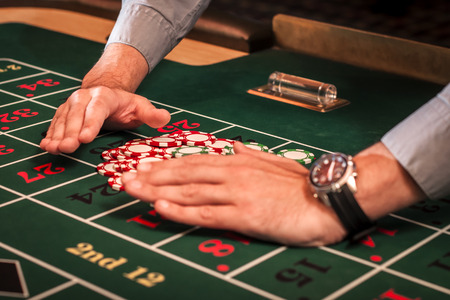 Casino dealer is clearing the table of the losing betsの写真素材