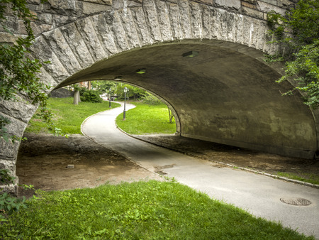 Path going under a stone bridge in Central Parkの写真素材