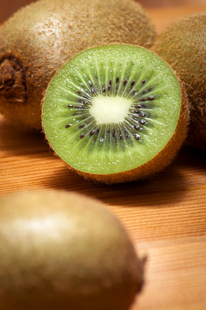 Sliced kiwi on a rustic wooden table, a great option for a refreshing and healthy snack.の写真素材
