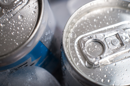 Top of aluminum cans of soda pop covered in ice and droplets of waterの写真素材