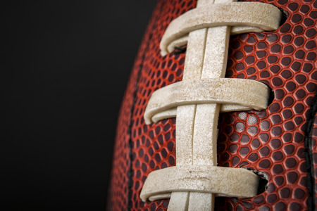 Macro of a vintage worn american football ball with visible laces, stitches and pigskin patternの写真素材