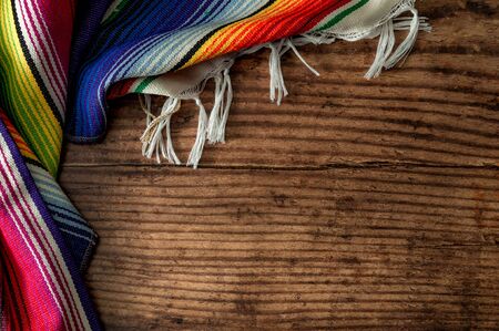 Cinco de mayo fiesta party and indigenous cultures of Mexico concept theme with a Mexican rug called a serape isolated on wood background with copy spaceの写真素材