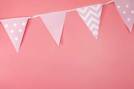 Minimalist party decorations and festive event concept with monochromatic photograph of vintage bunting (triangle papers hanging on string as banners) isolated on vivid pink background with copyspaceの写真素材