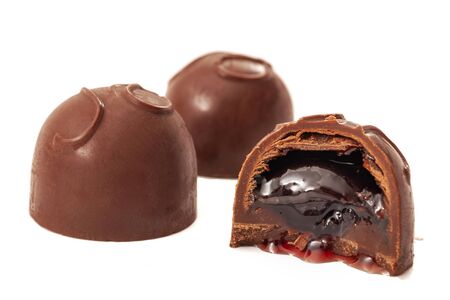 Sweet temptation conceptual idea with chocolate covered cherries or cordials isolated on white...