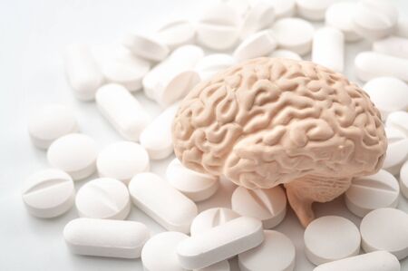 Nootropics use to improve memory and neural function, smart drugs and cognitive enhancers conceptual idea with brain and pills isolated on white backgroundの写真素材
