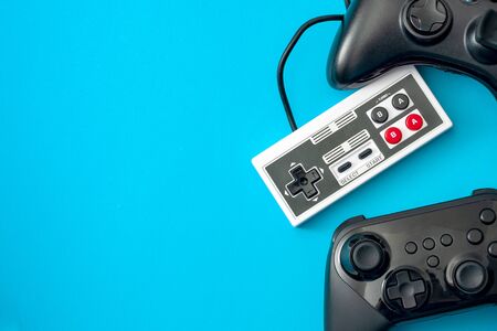 Computer games and gaming console concept theme with video game controllers isolated on blue...