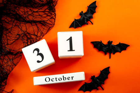 Happy Halloween and fall holiday concept with a calendar showing october 31, bats and black spider webの写真素材
