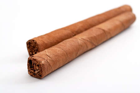 Masculine or macho lifestyle and tobacco smoking concept with two hand rolled cigars isolated on...