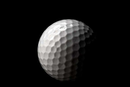 High contrast studio shot of golf ball isolated on black background with dramatic lightの写真素材