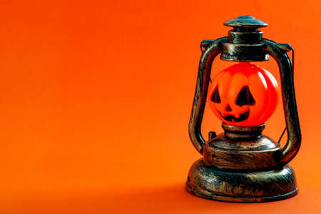 Halloween and fall holiday concept with a jack o lantern isolated on orange background with copy spaceの写真素材