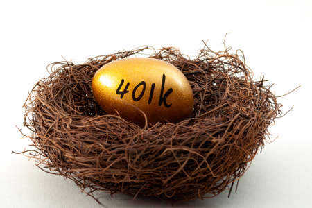 Individual retirement account, personal savings and pension fund concept with close up on a golden egg in a nest symbolizing the accumulated wealth with the text 401k, isolated on white  backgroundの写真素材