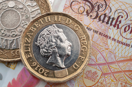 Business and finance, British economy and currency exchange concept with macro close up on one pound and two pounds coins and 10 GBP bank noteの写真素材