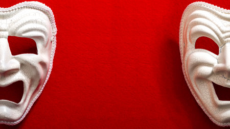 Comedy and Tragedy theatrical mask isolated on a red background and copy spaceの写真素材