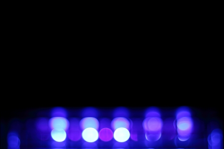 Abstract blurred purple bokeh on black background.