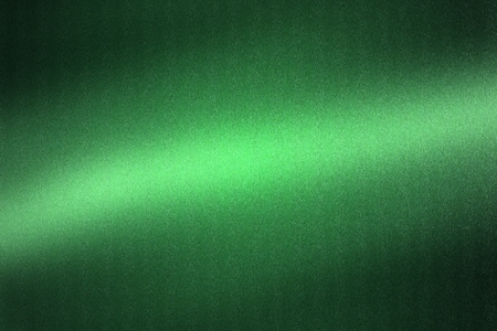Light shining on green metallic plate in dark room, abstract texture backgroundの写真素材
