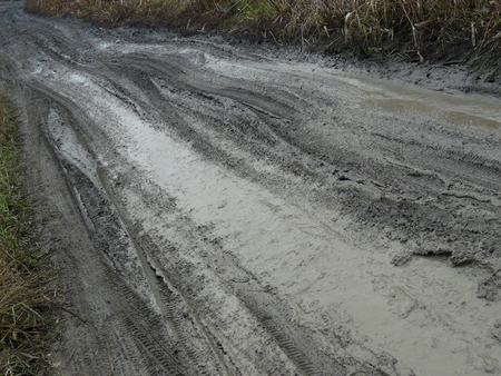 Dirty country road with blurred tire prints after rainの写真素材