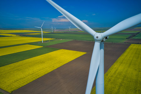 Aerial drone view of wind mills rotating by the force of the wind and generating renewable energy....